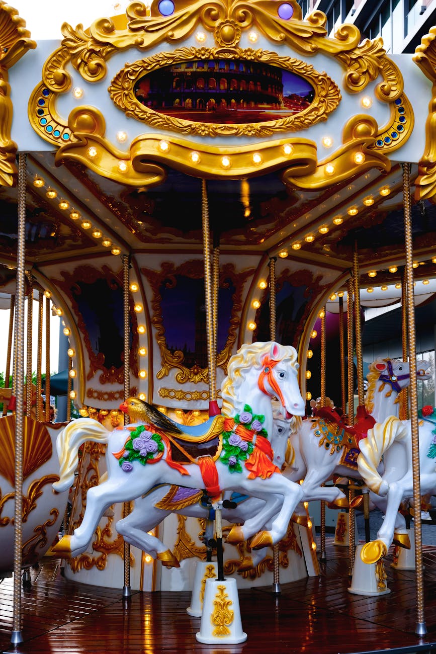 merry-go-round elaborately decorated. white horse center with painted flowers in front and behind multicolored saddle.