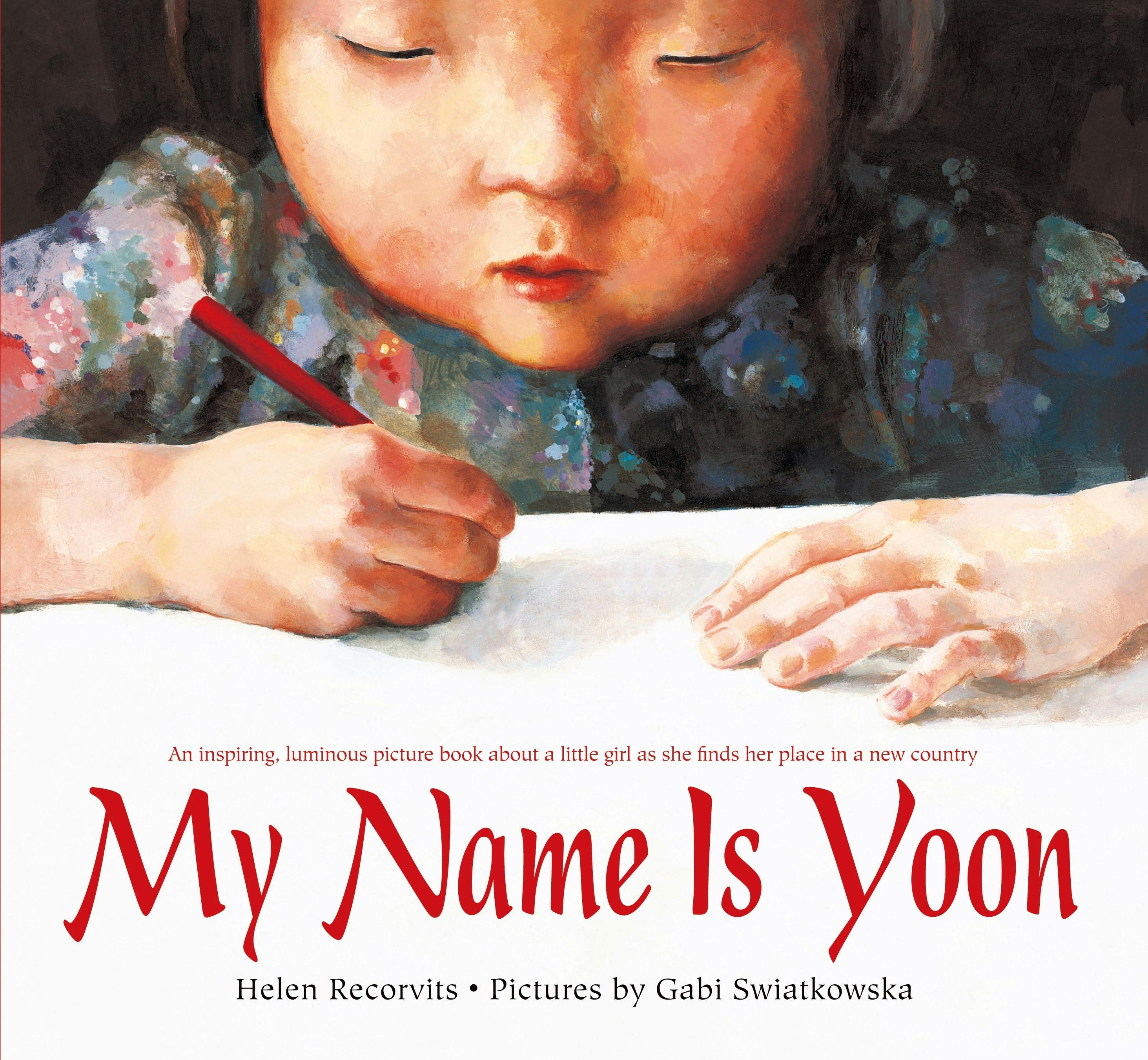 My Name Is Yoon, Book cover, painting of young Asian girl in floral top holding a red pencil and writing on the page in front of her.